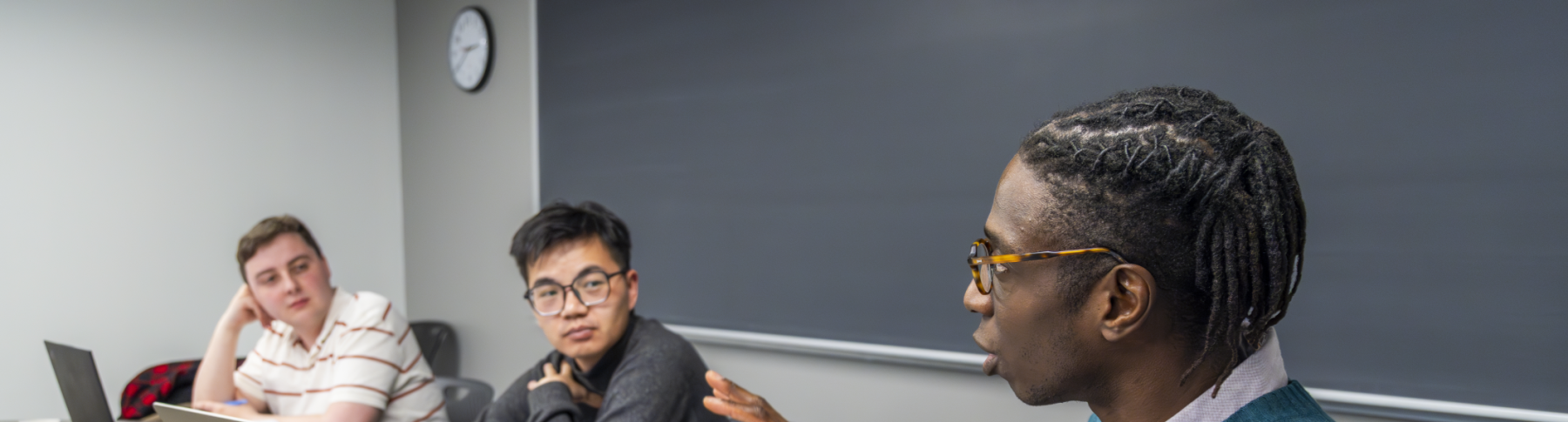 Professor Temi Ogunye speaking animatedly with graduate students