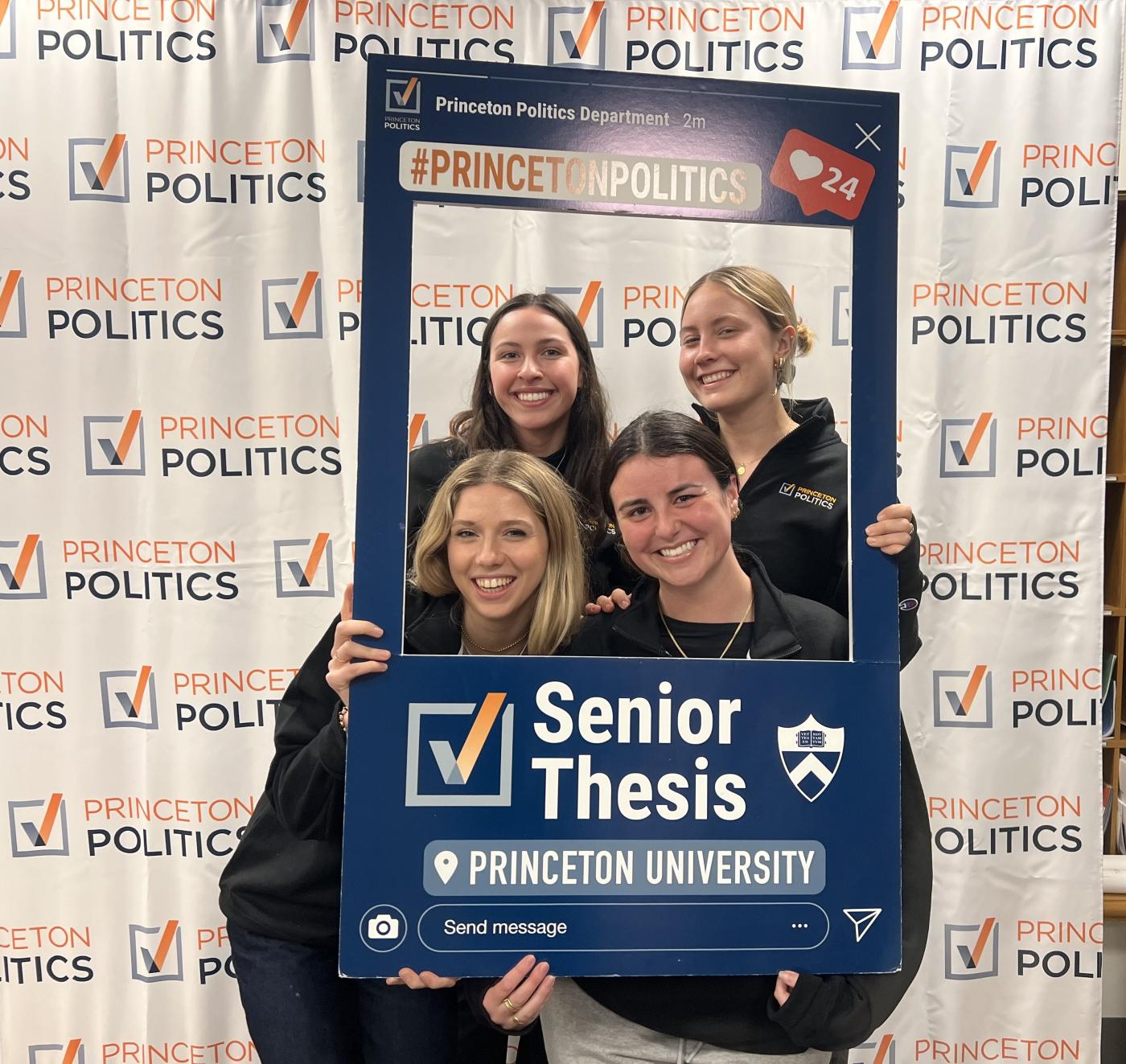 four students posing with senior thesis sign