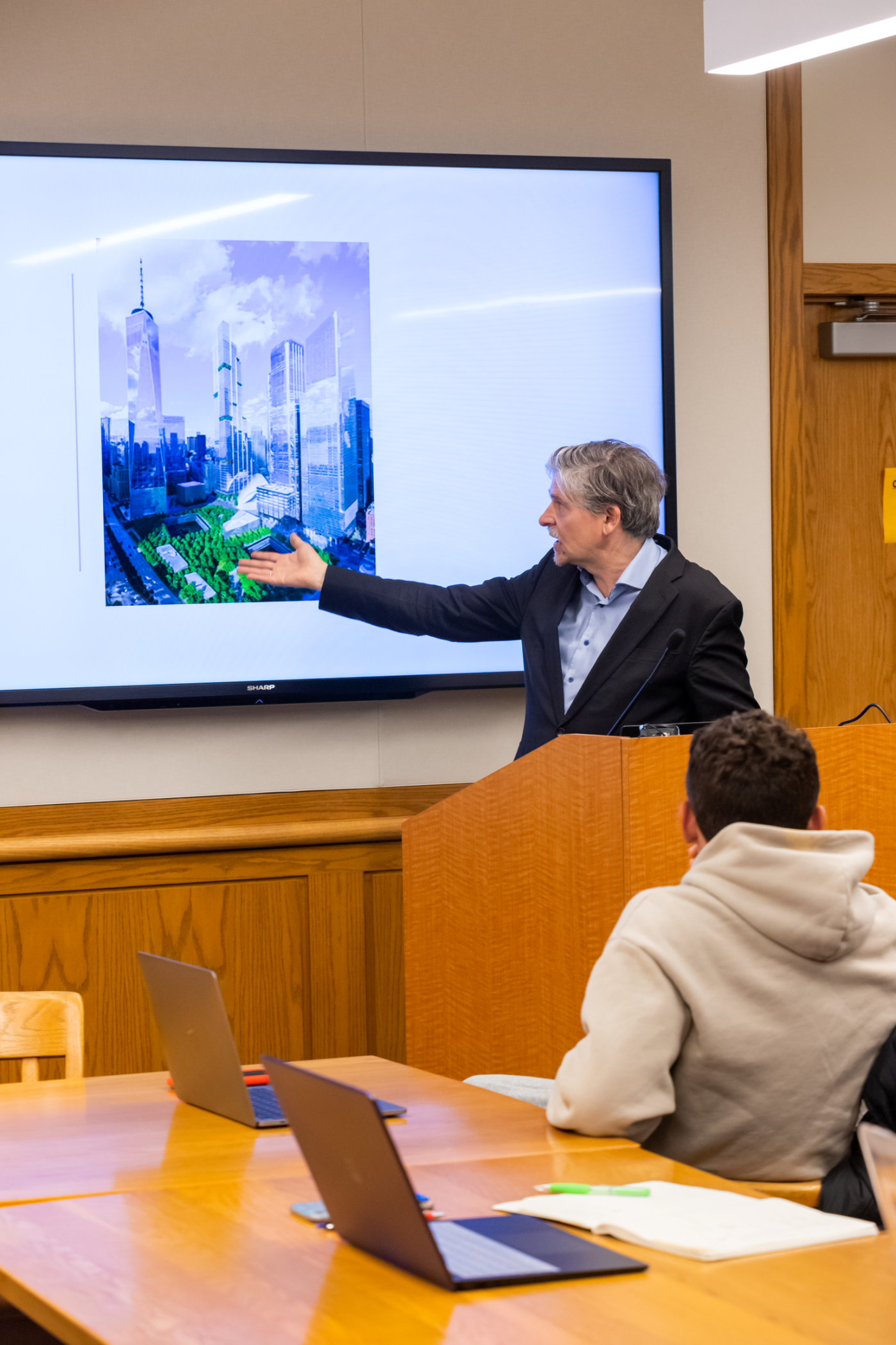 Professor Jan-Werner Müller pointing to a photo of the proposed design for Ground Zero in front of a class