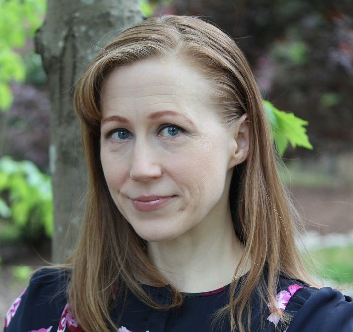 Corrine McConnaughy standing in front of a tree facing the camera