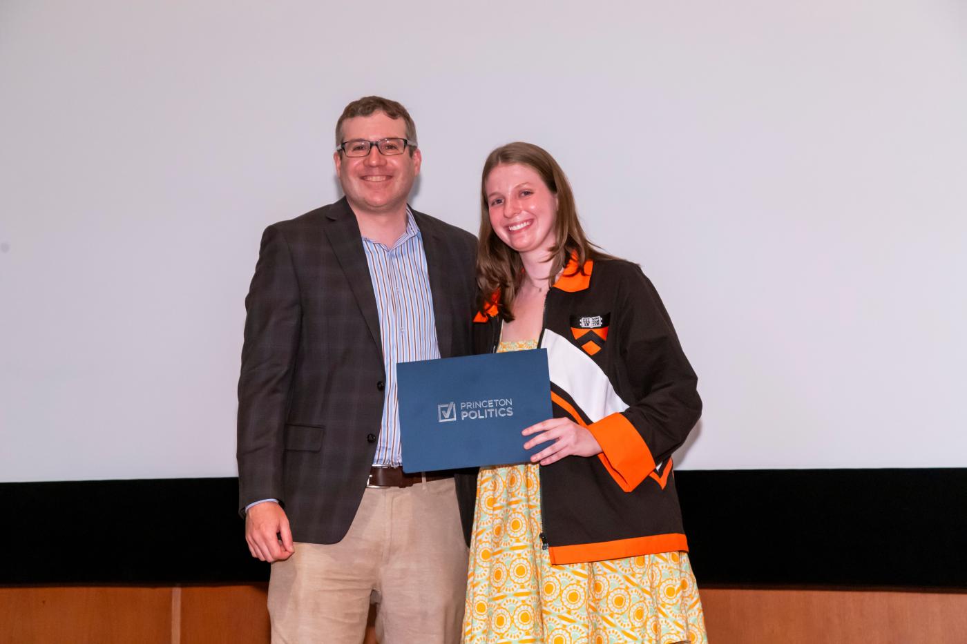 Kastellec posing with student winning an award