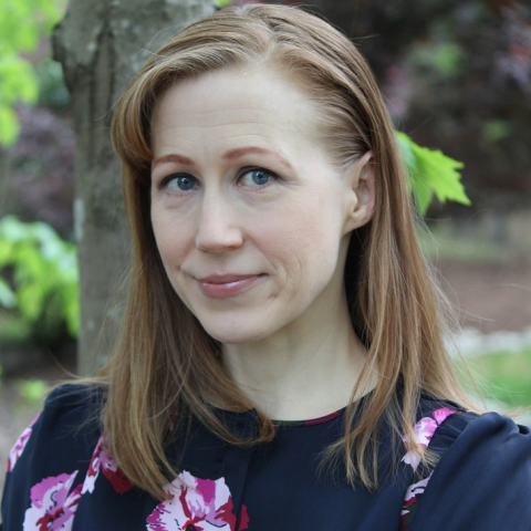 Corrine McConnaughy standing in front of a tree facing the camera